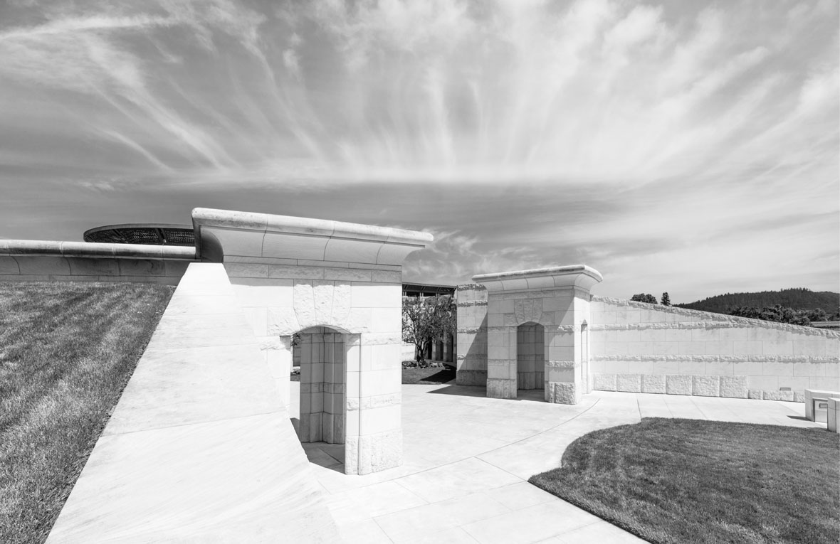 A beautiful black and white image of the Opus One building with clouds in the background